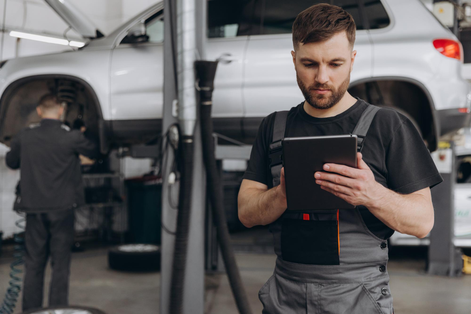 Técnico consultando el estado del vehículo en una tablet en taller